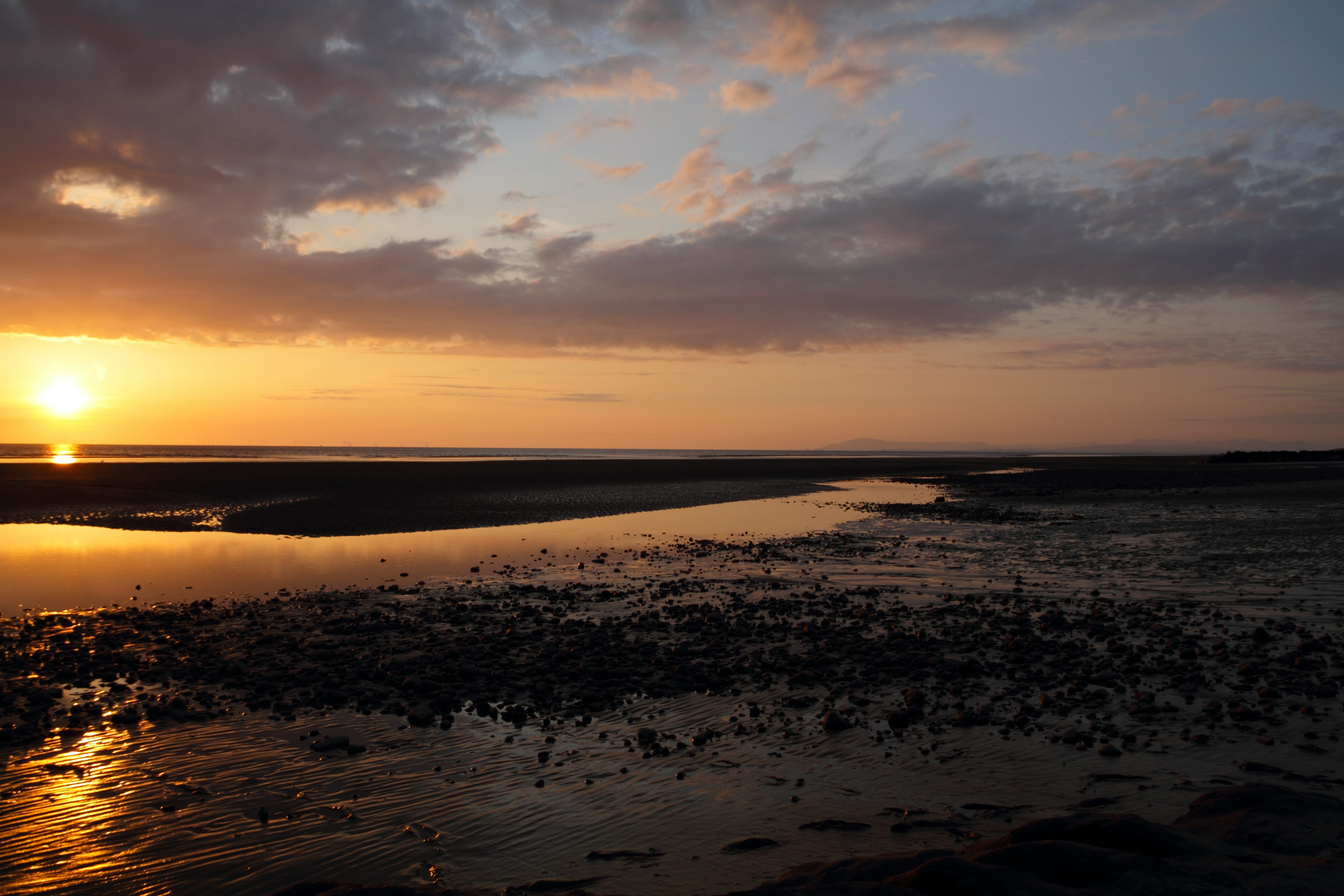 body of water under cloudy sky during sunset